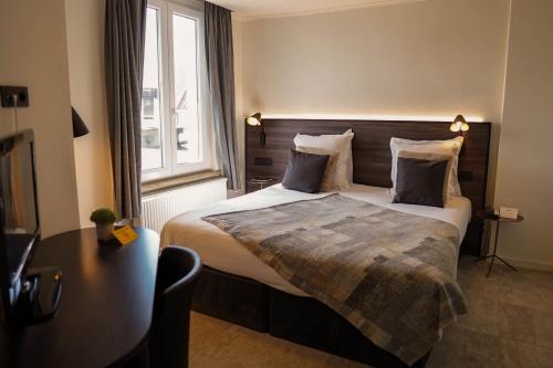 a hotel room with a bed and a window at Hotel Gravensteen in Ghent