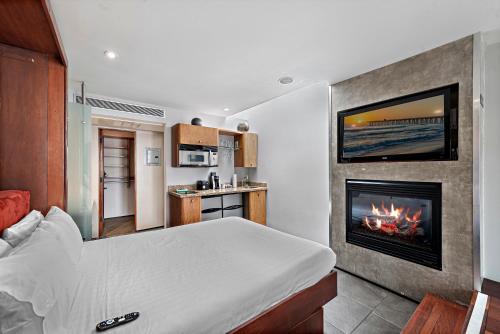 a bedroom with a bed and a fireplace at 14 West Boutique Hotel in Laguna Beach