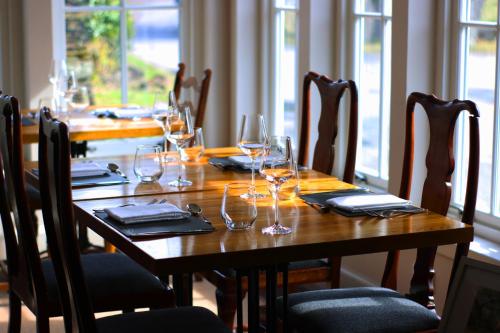 a wooden table with wine glasses and napkins on it at Tigh an Truish Inn in Oban