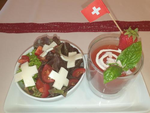 a salad and a drink on a tray with a flag at Hotel Sternen in Buochs