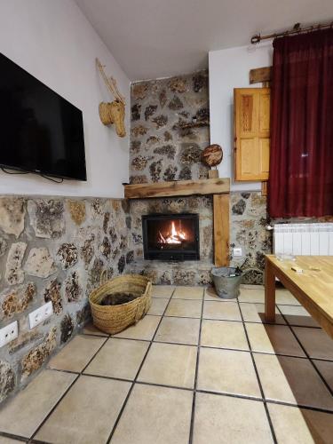 a living room with a fireplace and a tv at Casa el Escalerón in Uña