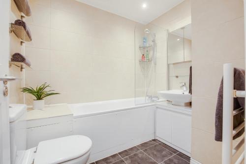 uma casa de banho branca com um WC e um lavatório em Mews In Marylebone - Prime Central London em Londres