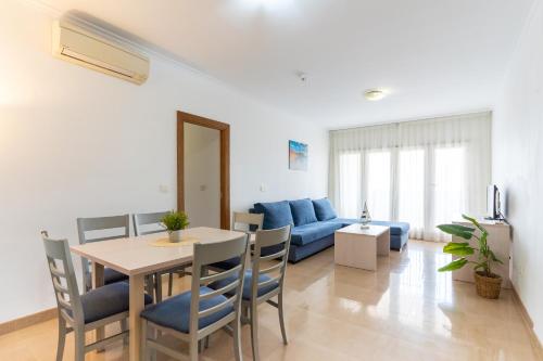 een woonkamer met een tafel en een blauwe bank bij Dream Sea Apartments in Almerimar