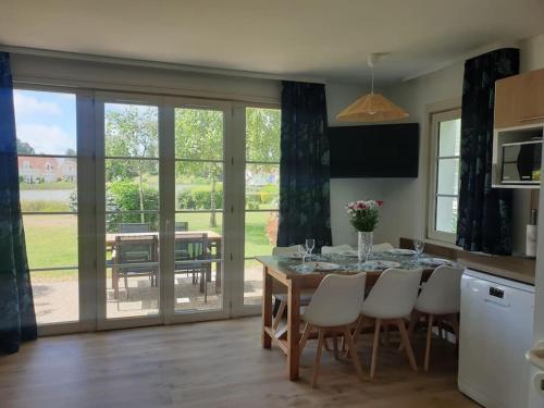 une cuisine avec une table avec des chaises et une salle à manger dans l'établissement Jolie maison sur golf, proche plage, Fort-Mahon, à Fort-Mahon-Plage