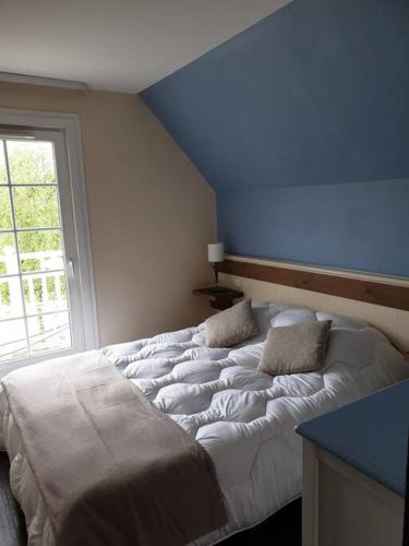 Cette chambre dispose d'un grand lit et d'un plafond bleu. dans l'établissement Jolie maison sur golf, proche plage, Fort-Mahon, à Fort-Mahon-Plage