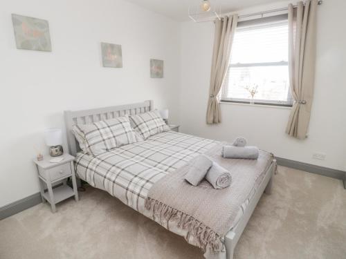 una camera da letto con un letto con due cuscini e una finestra di The Annexe a Berwick-Upon-Tweed