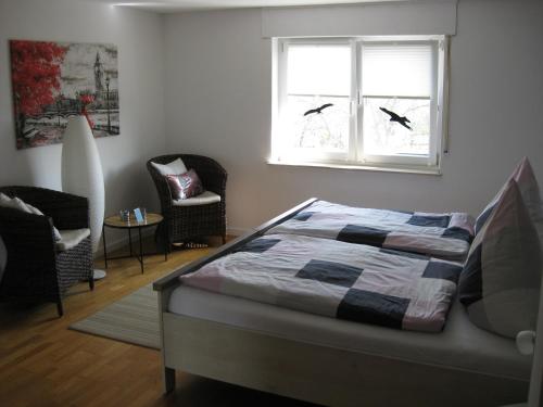 ein Schlafzimmer mit einem Bett, einem Fenster und einem Stuhl in der Unterkunft Bella Colonia Vieren in Hürth