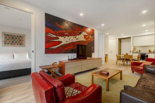 a living room with a couch and a bed and a television at Lovely 2 bedroom unit in North Melbourne - 03068 in Melbourne