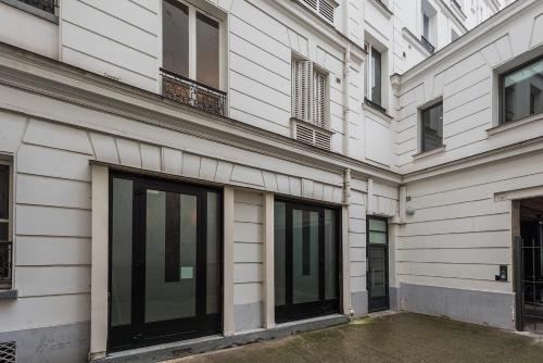 un bâtiment avec des portes en verre sur son côté dans l'établissement Charmant studio près des Champs-Élysées, à Paris