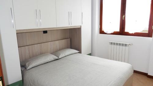 Affittimoderni Bergamo Curno CUMA11 في Curno: غرفة نوم بسرير ابيض في غرفة