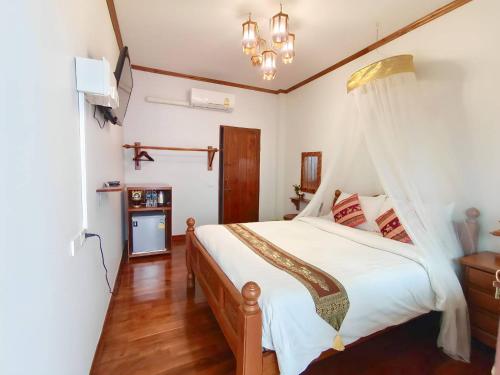 - une chambre avec un lit blanc à baldaquin dans l'établissement Apilapa Hotel, à Chiang Mai
