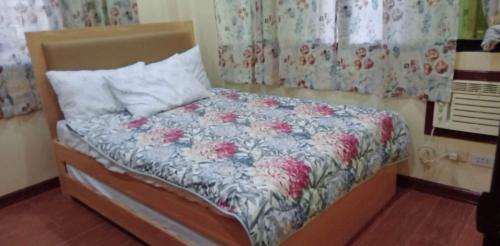 a small bed in a bedroom with flowers on it at Villa Ceferina Bohol in Tagbilaran City