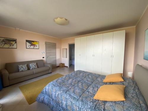 een slaapkamer met een bed en een bank bij Flowers and garden apartment in Manerba del Garda