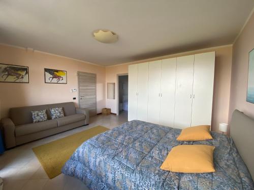 a bedroom with a bed and a couch at Flowers & garden apartment con vista lago in Manerba del Garda