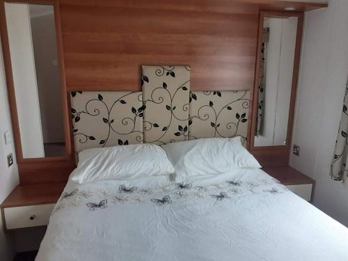 a white bed with two pillows on top of it at 19 orchid Meadows in Newbiggin-by-the-Sea