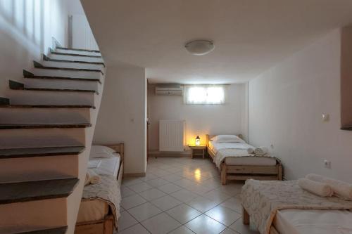 a room with two beds and a stair case at "Triacanthos" 2 bedroom house in Moutsoúna