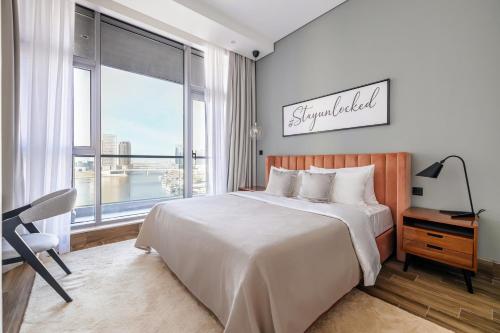 - une chambre avec un grand lit et une grande fenêtre dans l'établissement Unlock J One Downtown Dubai, à Dubaï