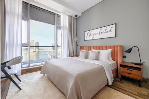 a bedroom with a large bed and a large window at Unlock J One Downtown Dubai in Dubai