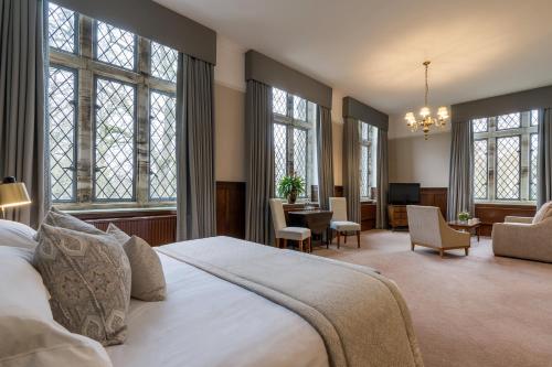 a bedroom with a large white bed and windows at Ashdown Park Hotel in Forest Row
