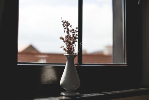 a white vase sitting in front of a window at Penzión ÁTRIUM in Prešov