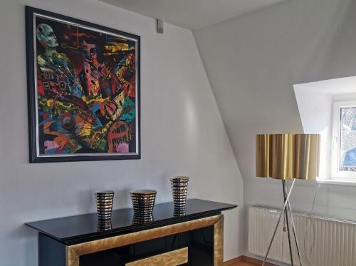 ein Wohnzimmer mit einem Kamin und einem Wandgemälde in der Unterkunft Apartment in Villa Rochlitz in Rochlitz