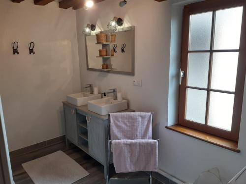uma casa de banho com 2 lavatórios e um espelho em Gîte de la Ferme de la Côte em Les Damps