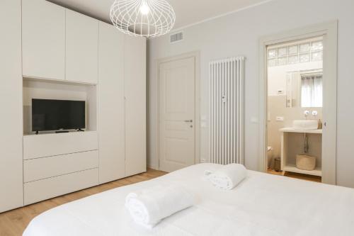 a white bedroom with a bed and a tv at Treviso City Town 4 in Treviso