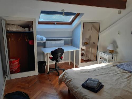 a bedroom with a bed and a desk and a window at Comme à la maison ! in Caluire-et-Cuire