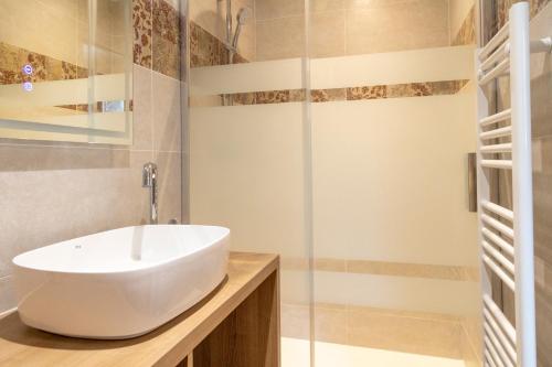 y baño con lavabo blanco y ducha. en Gîte au bord du Cher "La Mésange Verte", en Savonnières