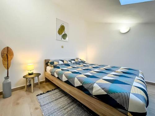 een slaapkamer met een bed met een blauw en wit dekbed bij Agape Apartment in Novi Vinodolski