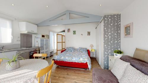 un salon avec un lit et une cuisine dans l'établissement Escale Oceane 5 minutes des plages, à Saint-Hilaire-de-Riez