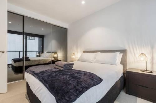 a bedroom with a large bed and a large window at Nice 1 bedroom close to Albert Park Lake 02053 in Melbourne