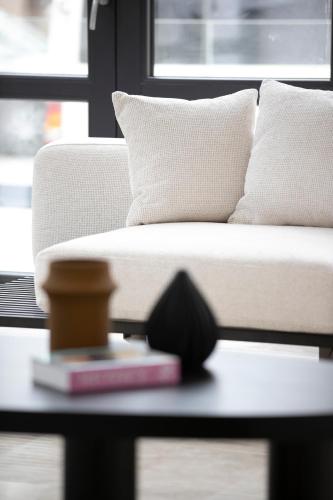a living room with a couch and a table with a book at Cosmopolita Boutique Hotel in Timişoara