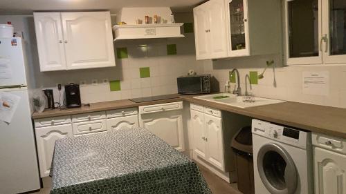 a kitchen with white cabinets and a washing machine at Comme à la maison ! in Caluire-et-Cuire