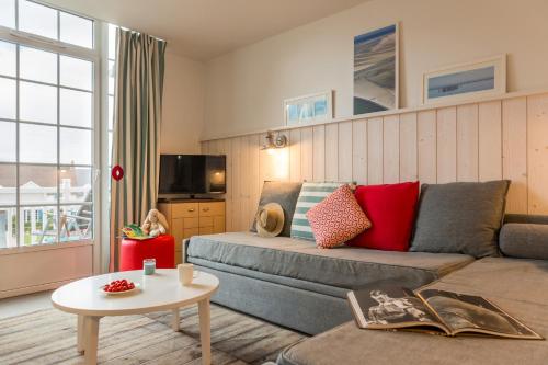 a living room with a couch and a table at Pierre & Vacances Premium Résidence de la Plage in Le Crotoy