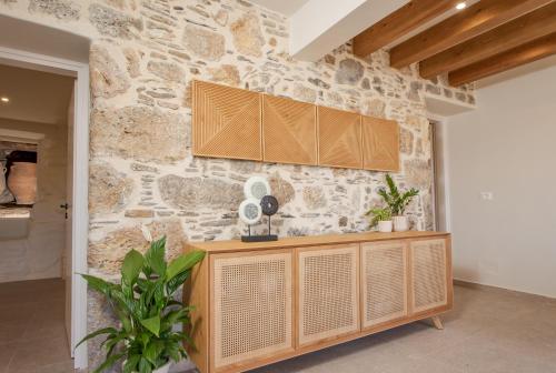 a stone wall in a kitchen with a wooden cabinet at Elirion Luxury Home in Kamária