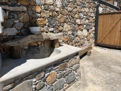a stone wall with a wooden bench next to a door at Elirion Luxury Home in Kamária