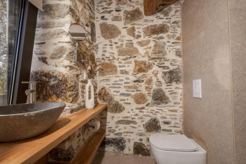 a stone bathroom with a sink and a toilet at Elirion Luxury Home in Kamária