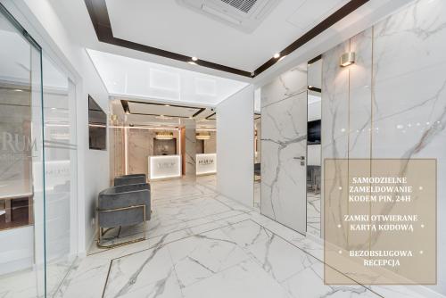 a lobby with marble flooring and a black chair at Aurum Aparthotel - Nowe Apartamenty blisko Plaży - Neue Appartements in Strandnähe in Świnoujście