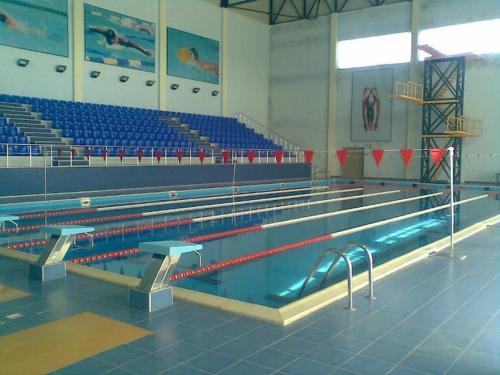 an empty swimming pool in a gym with blue seats at Qusar Olimpik Hotel and Cottages in Qusar