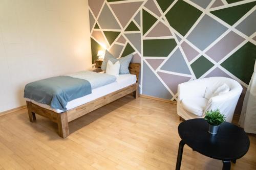 niewielka sypialnia z łóżkiem i krzesłem w obiekcie Zimmerfrei-Barz w mieście Ahlefeld