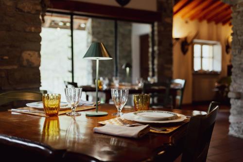 een houten tafel met een lamp en glazen erop bij Locanda del Daino 