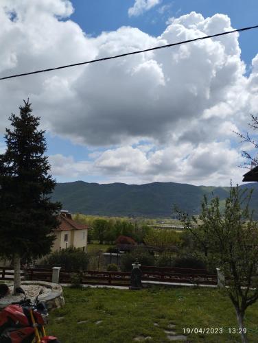 a view of a field with a tree and mountains at Mavridis House in Eleftheroúpolis