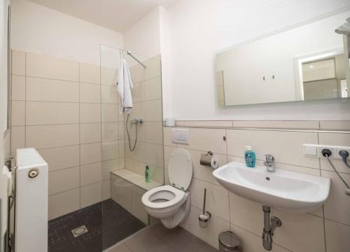 a white bathroom with a toilet and a sink at Apartment central in Bad Saulgau