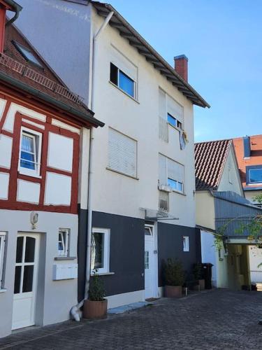 a white building with red accents next to a street at Apartment central in Bad Saulgau