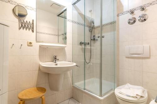 een badkamer met een douche, een wastafel en een toilet bij Villa-Eden-Typ-1 in Binz