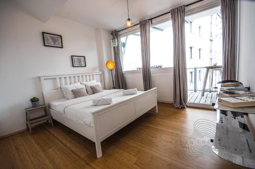 1 dormitorio con cama blanca y ventana grande en URBAN LOFT // CITY CENTER // BEST LOCATION VILLACH, en Villach