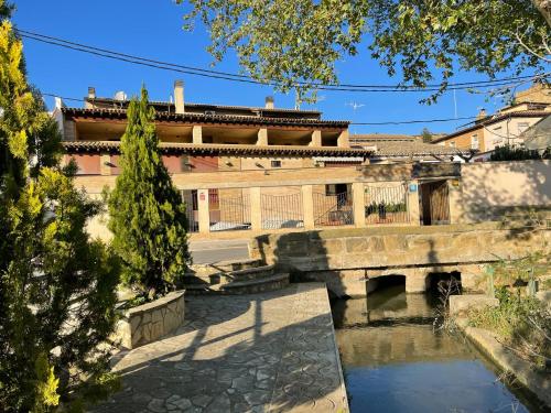 um edifício antigo com uma ponte sobre um rio em EL RINCON DE TOÑO em Pomar