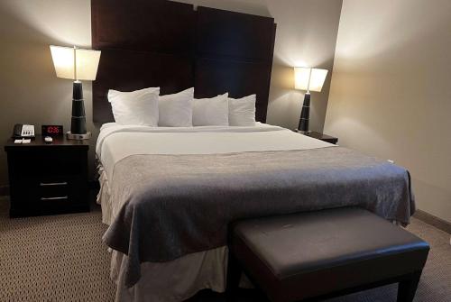 a large bed in a hotel room with two lamps at Baymont by Wyndham College Station in College Station