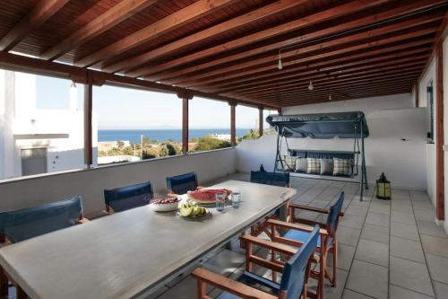 a dining room with a table and chairs and the ocean at "Triacanthos" 3 bedroom house in Moutsoúna